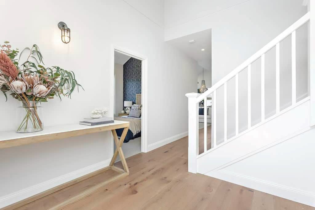 A Hallway with A Table and Stairs in A House — Evolution Building Group Dapto, NSW