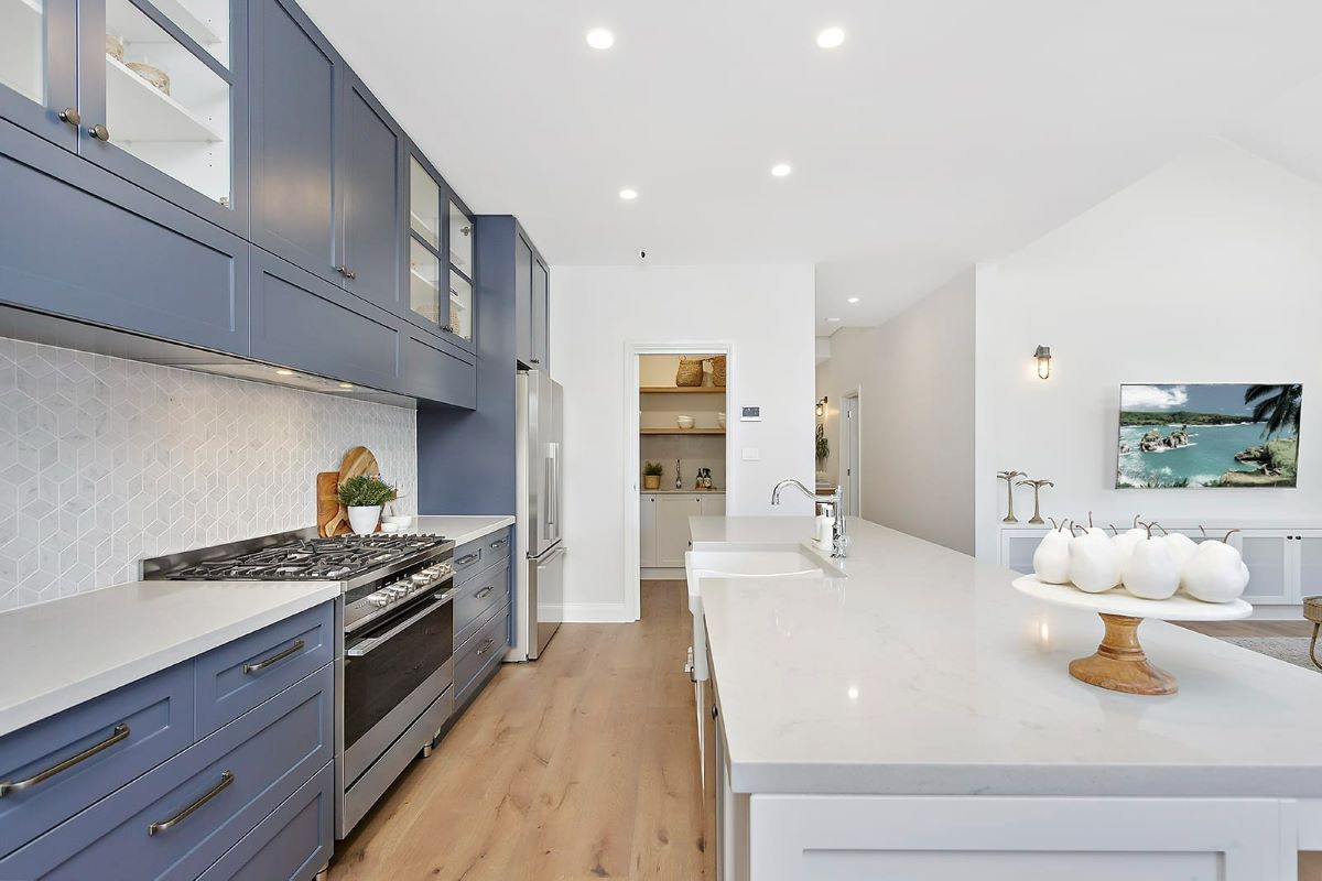 A Kitchen with Blue Cabinets and White Counter Tops — Evolution Building Group Dapto, NSW