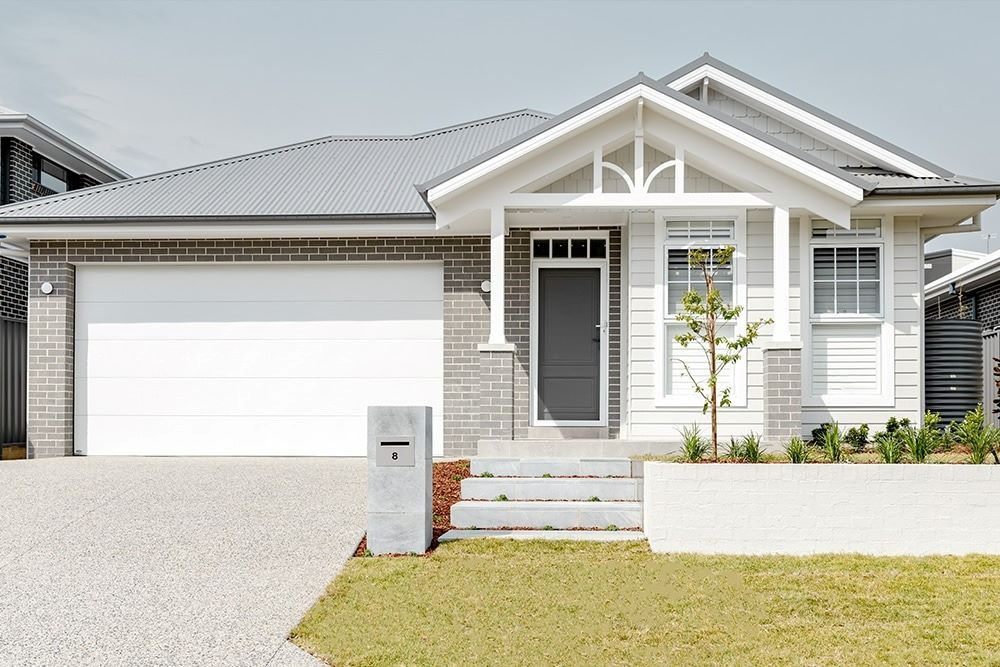 A White House with A Grey Roof and A White Garage Door — Evolution Building Group Dapto, NSW