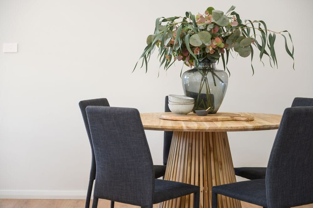 A Dining Room Table with A Vase of Flowers on Top of It — Evolution Building Group Dapto, NSW