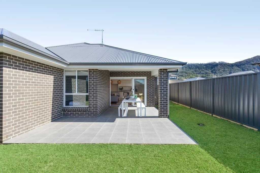 A Brick House with A Patio and A Black Fence — Evolution Building Group Dapto, NSW