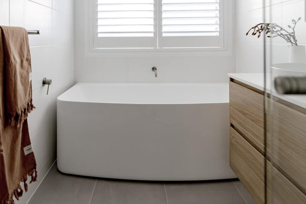 A Bathroom with A Bathtub, Sink, and Window — Evolution Building Group Dapto, NSW