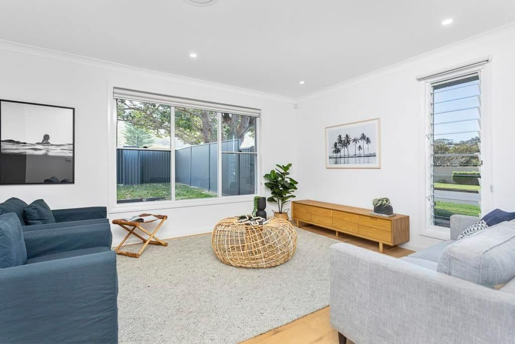 A Living Room with A Blue Couch and A Wicker Coffee Table — Evolution Building Group Dapto, NSW