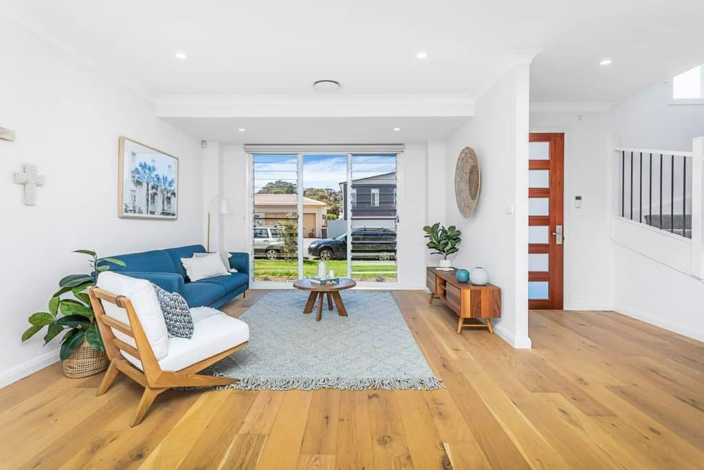 A Living Room with Hardwood Floors and A Blue Couch — Evolution Building Group Dapto, NSW