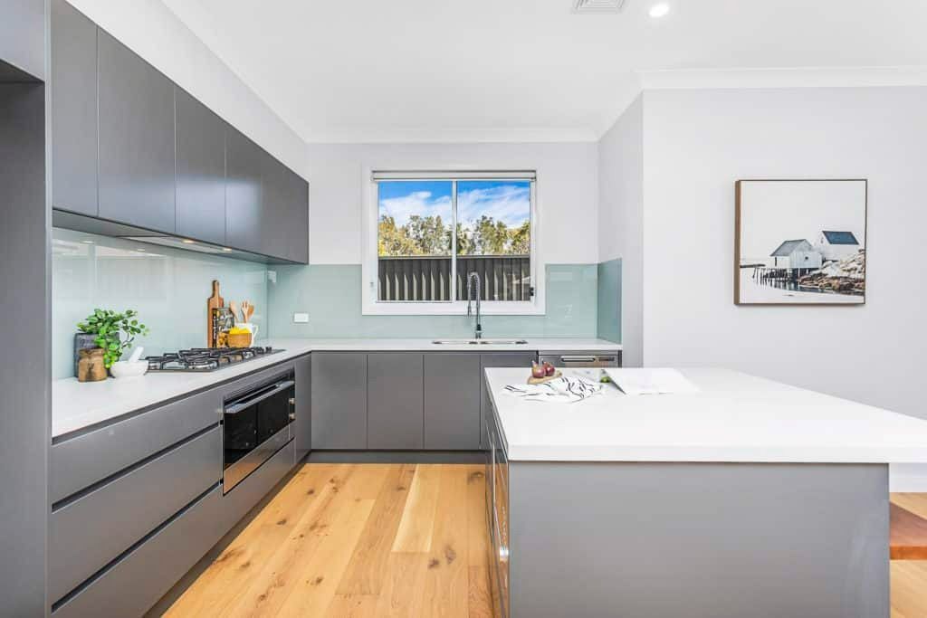 A Kitchen with A Large Island in The Middle and A Large Window — Evolution Building Group Dapto, NSW