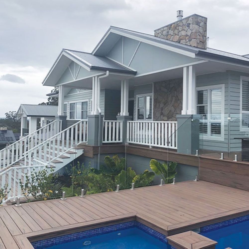 A Large House with A Swimming Pool in Front of It — Evolution Building Group Dapto, NSW