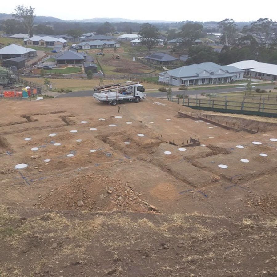 A White Truck Is Parked in The Middle of A Dirt Field — Evolution Building Group Dapto, NSW