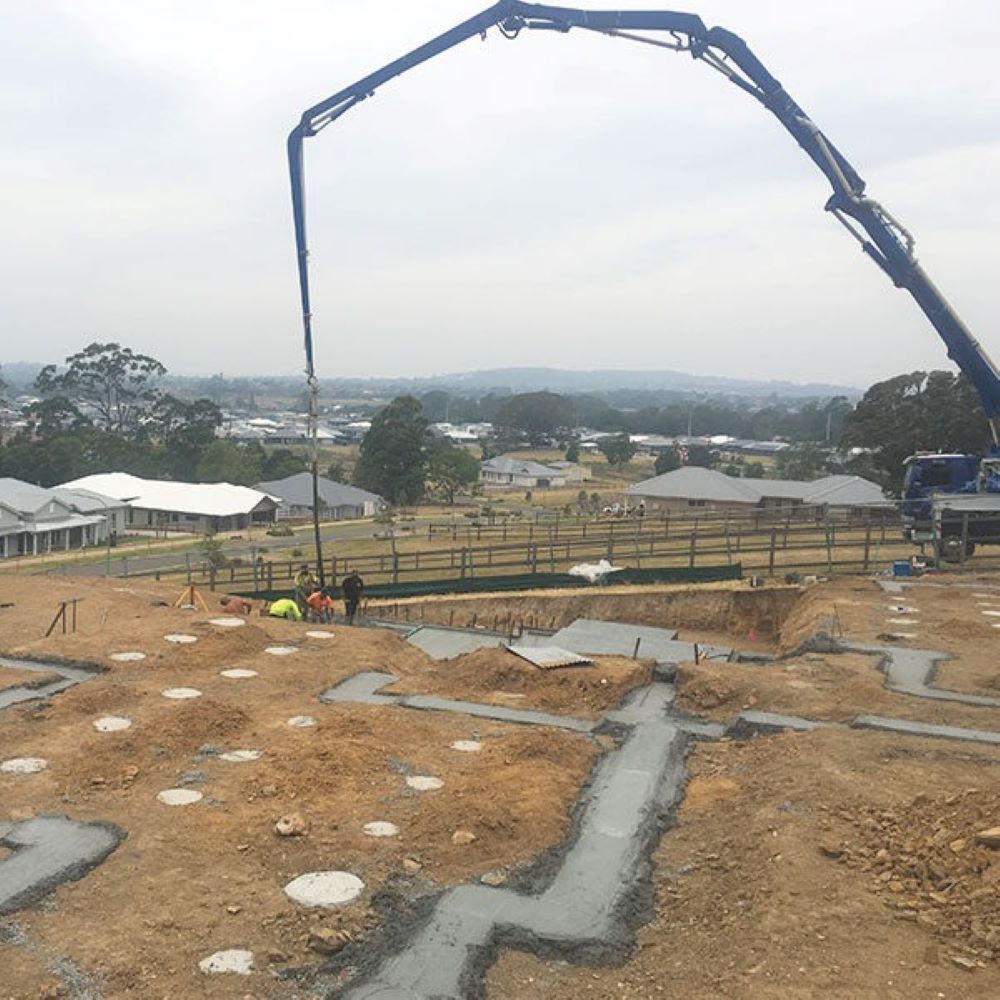 A Concrete Pump Is Being Used on A Construction Site — Evolution Building Group Dapto, NSW