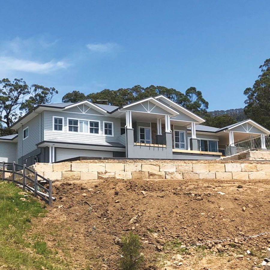 A Large White House Is Sitting on Top of A Dirt Hill — Evolution Building Group Dapto, NSW