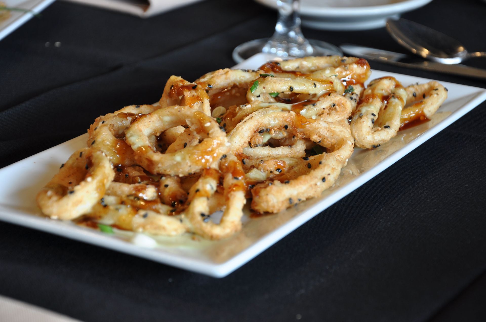 A white plate topped with fried squid on a table