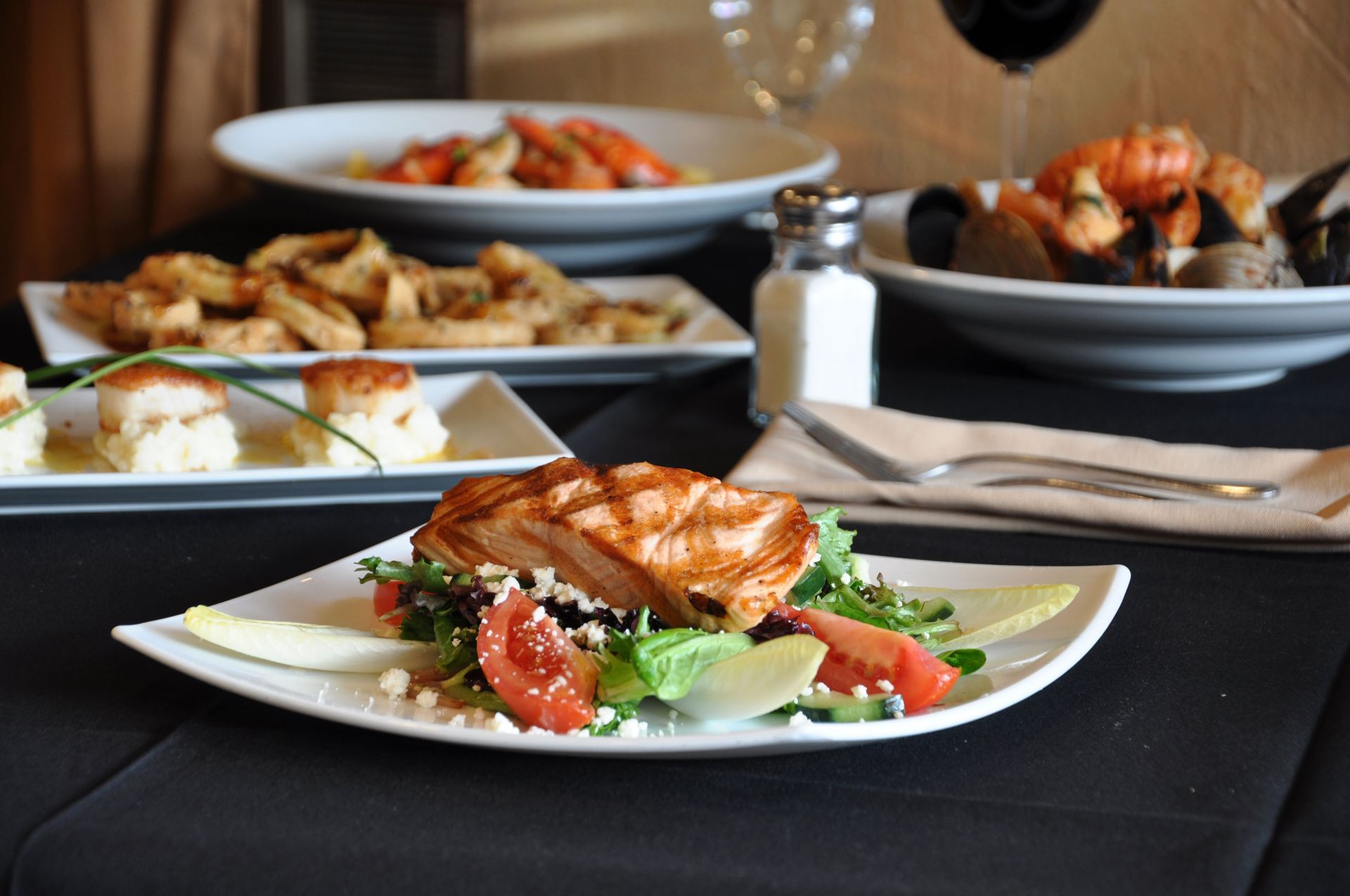 A plate of food on a table with a glass of wine