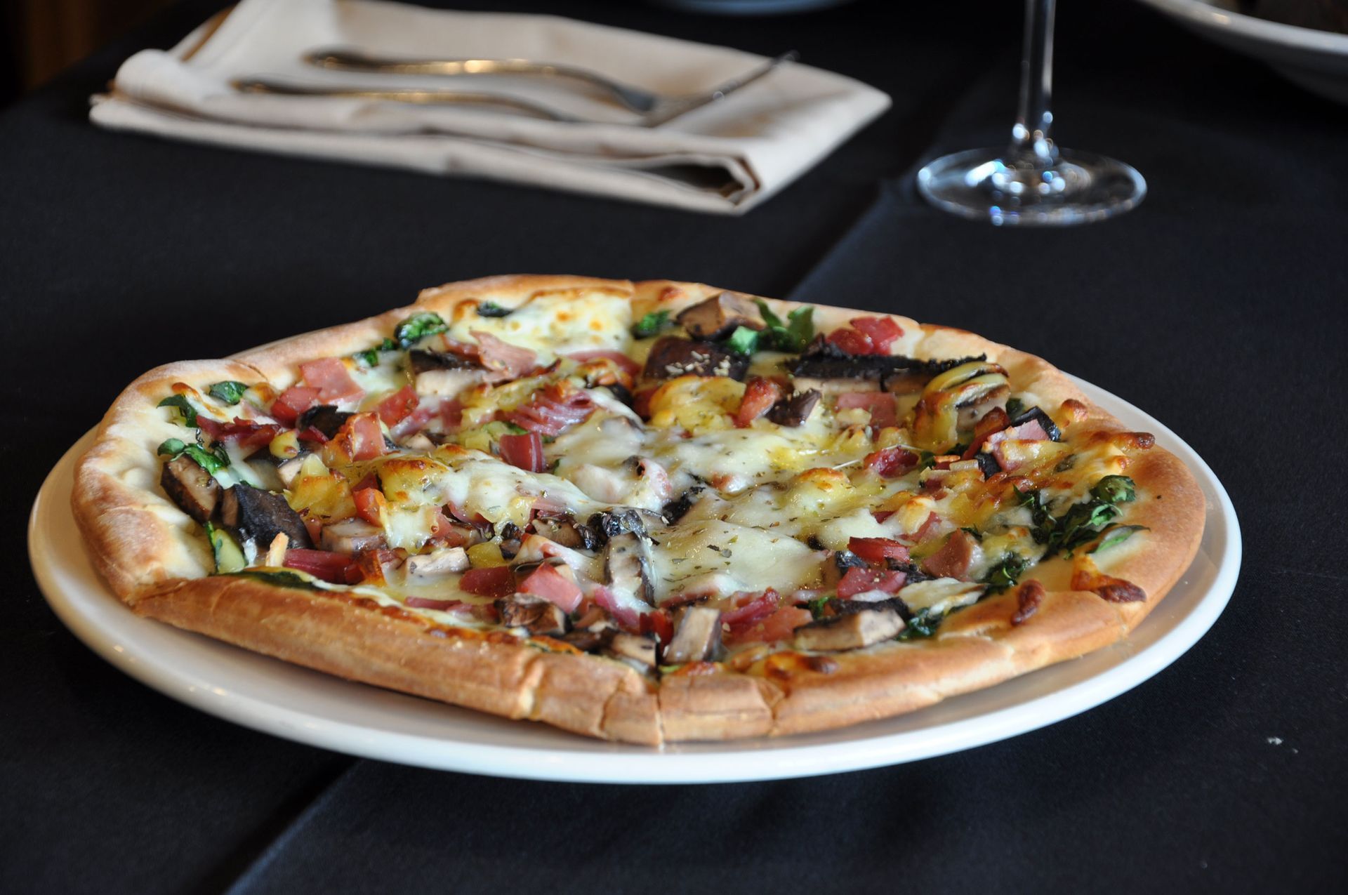 A pizza is on a white plate on a table