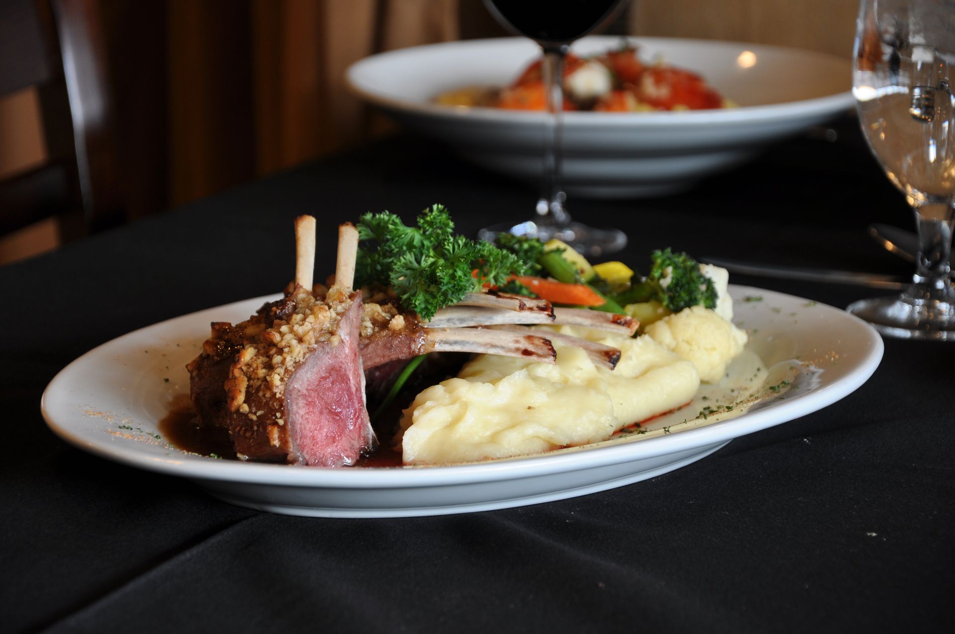 A plate of lamb chops and mashed potatoes on a table