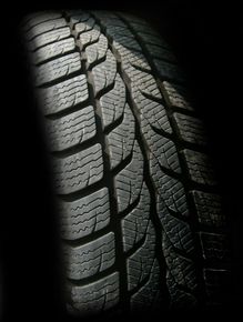 A close up of a tire on a black background