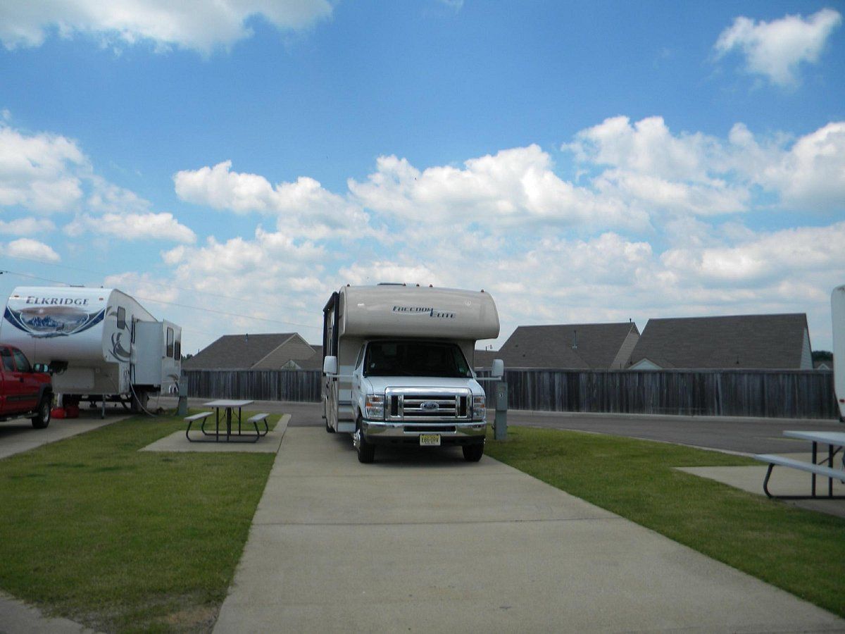 A white rv is parked in a parking lot