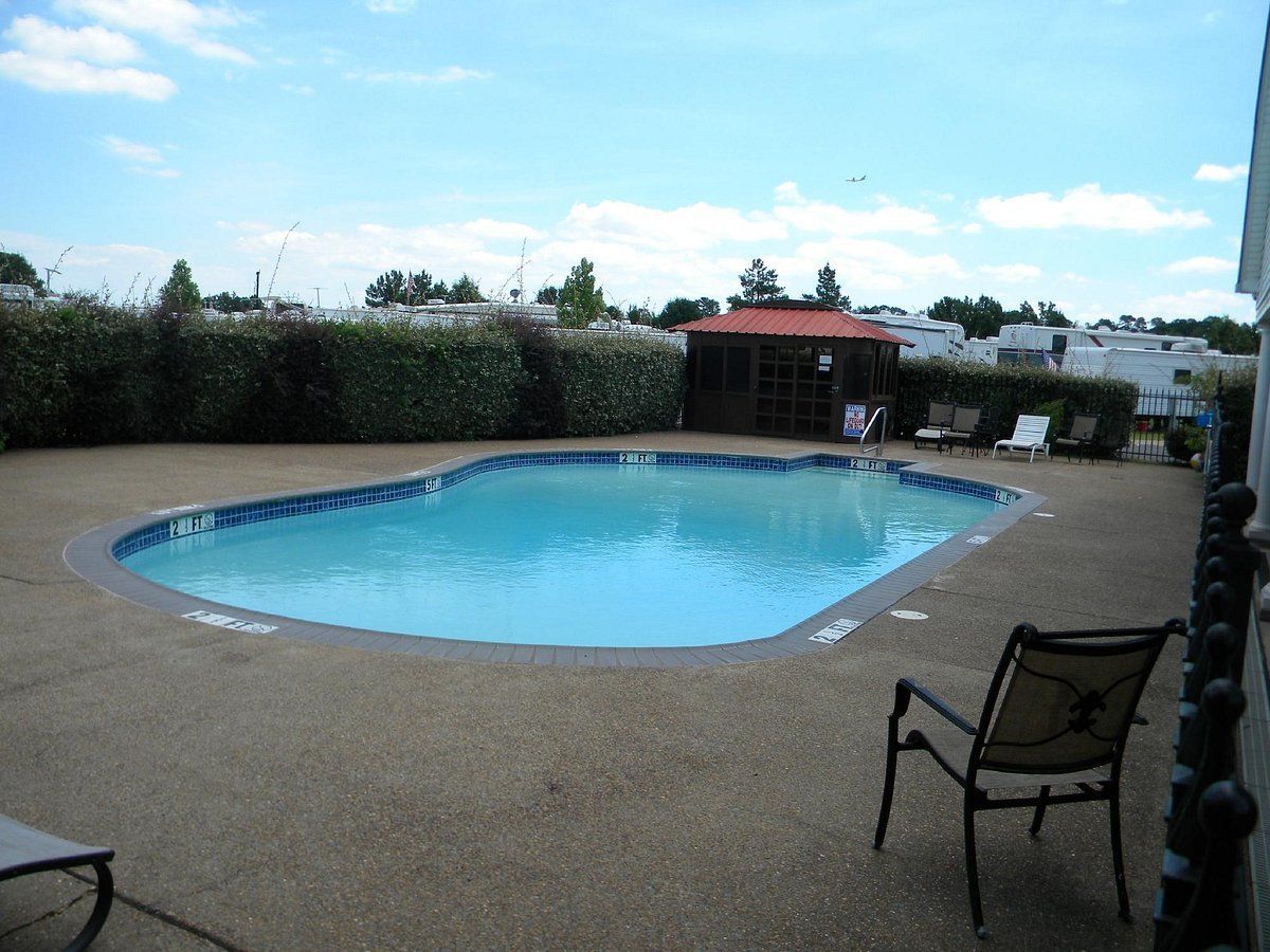 A large swimming pool with a gazebo in the background