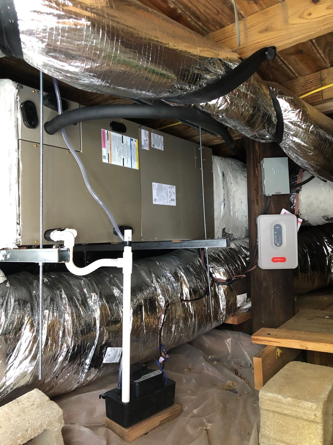 A room with a lot of ducts and pipes hanging from the ceiling.
