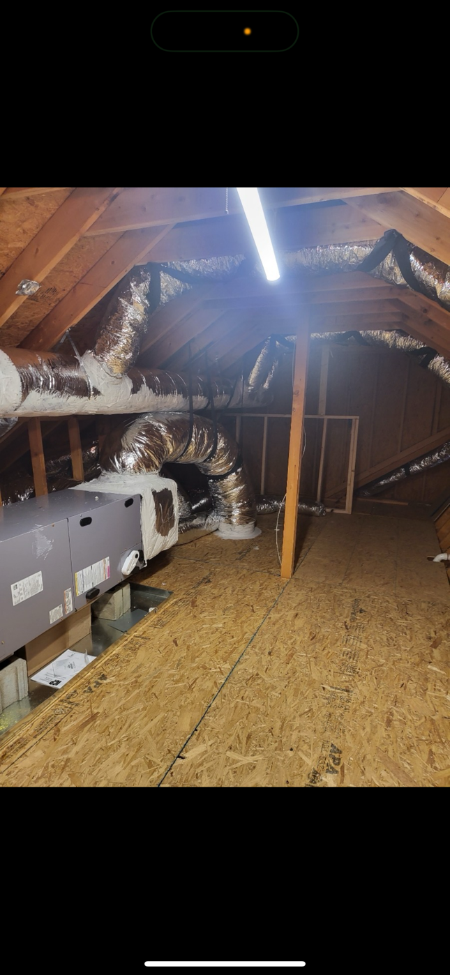 A picture of an attic with a lot of pipes coming out of it.