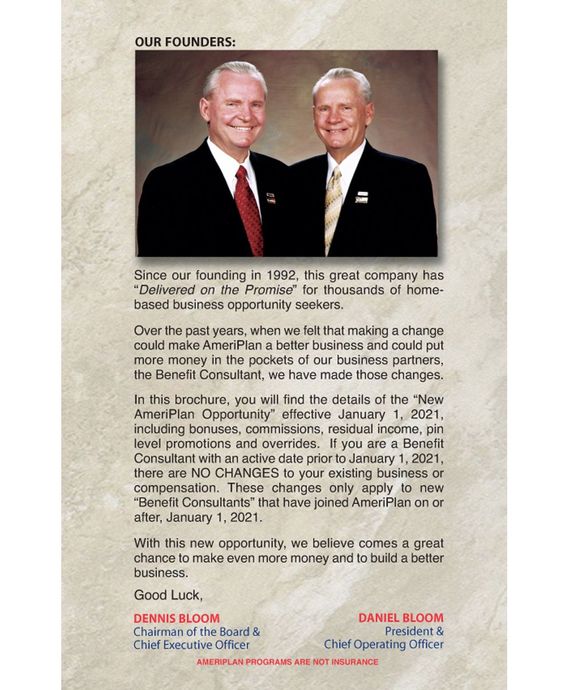 Two men in dark suits stand side by side beside a “Our Founders” tribute plaque.
