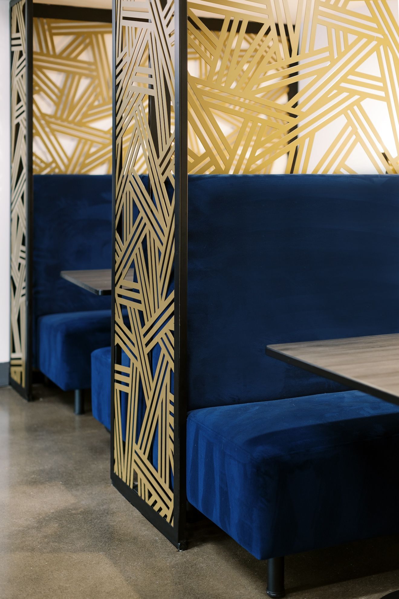 A row of blue booths with tables in a restaurant.