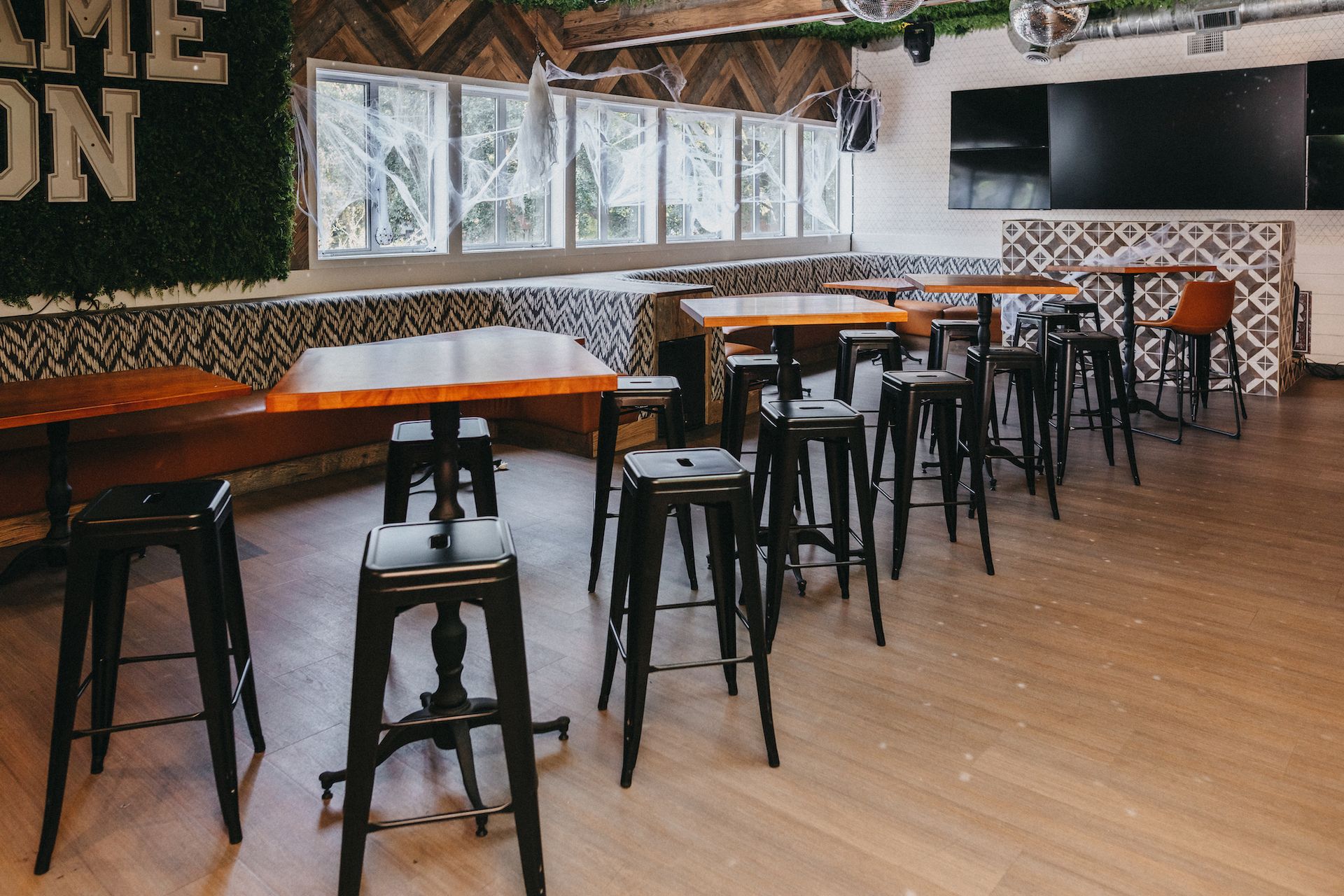 A restaurant with tables and stools.