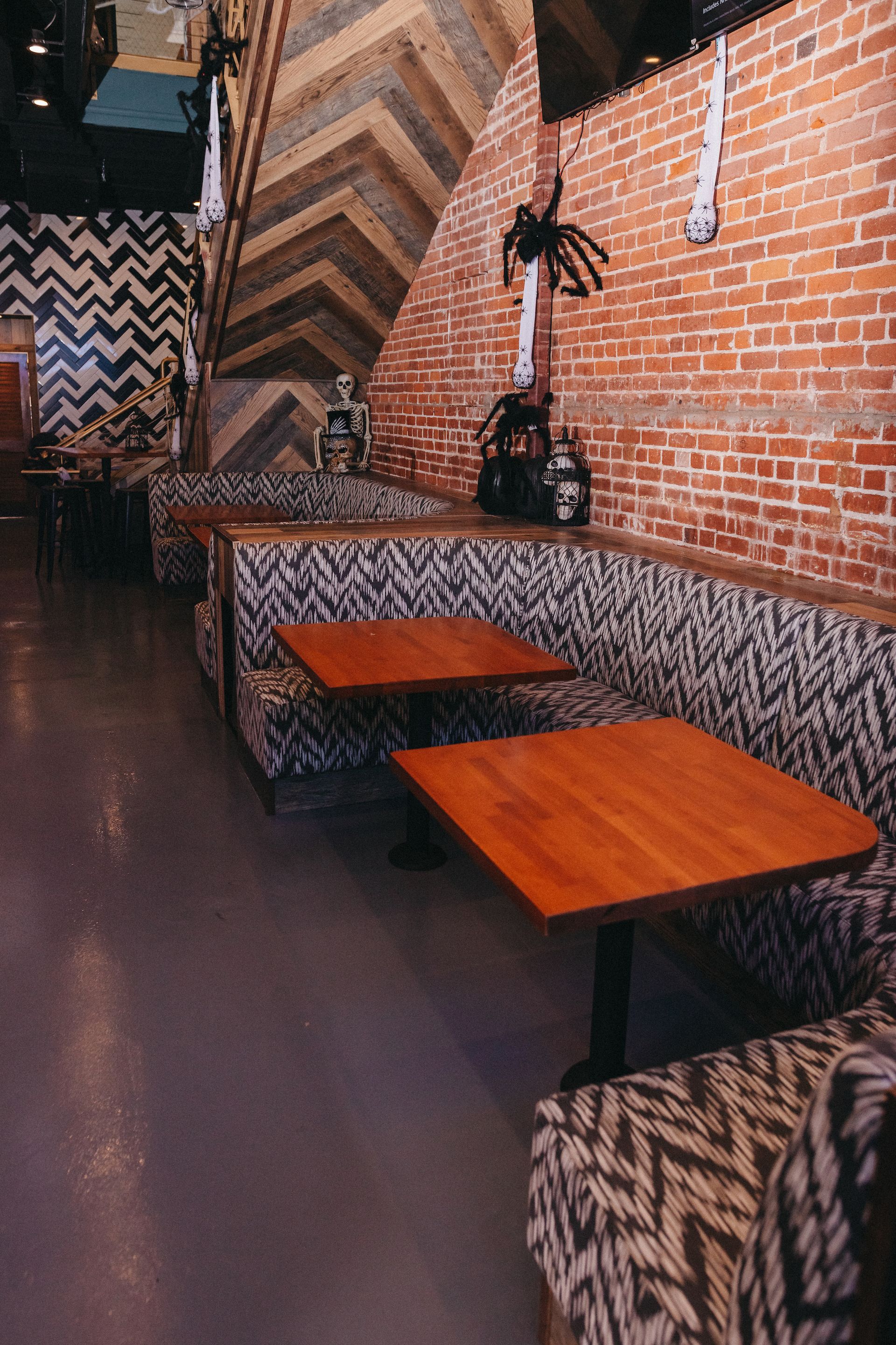 A restaurant with tables and chairs and a brick wall.