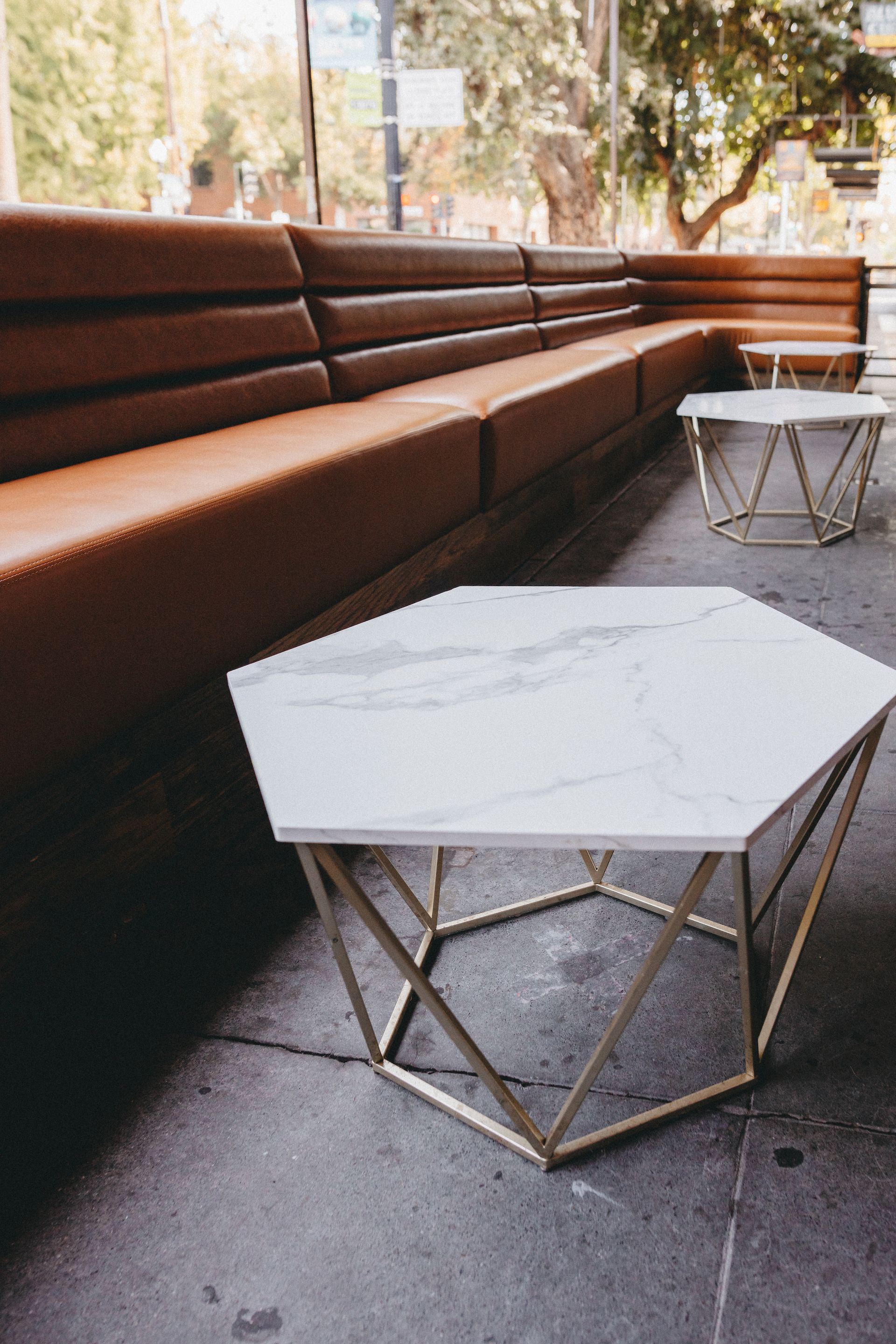 A table with a marble top is sitting in front of a couch.