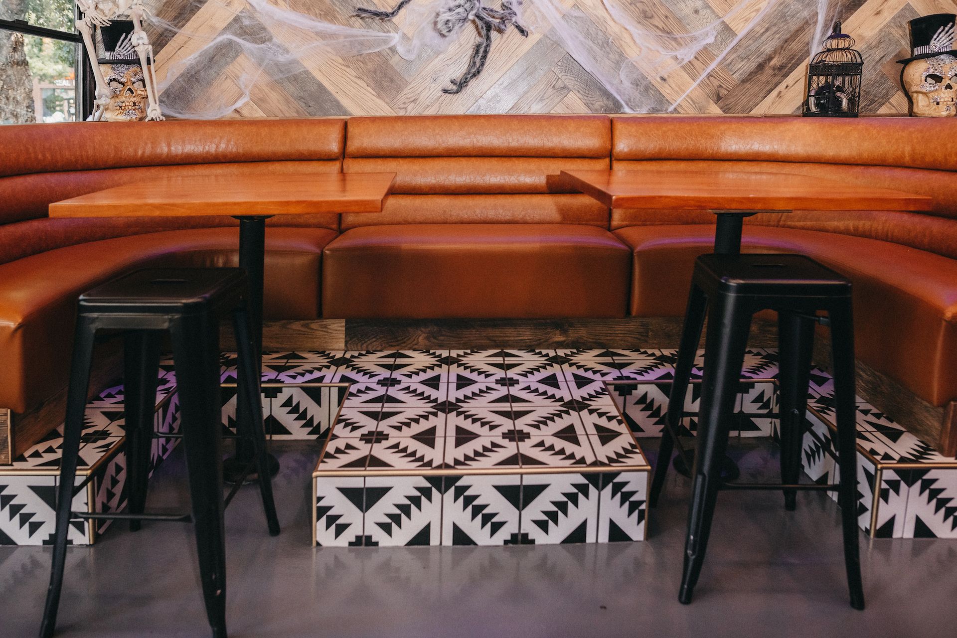 A restaurant with a couch , tables and stools.