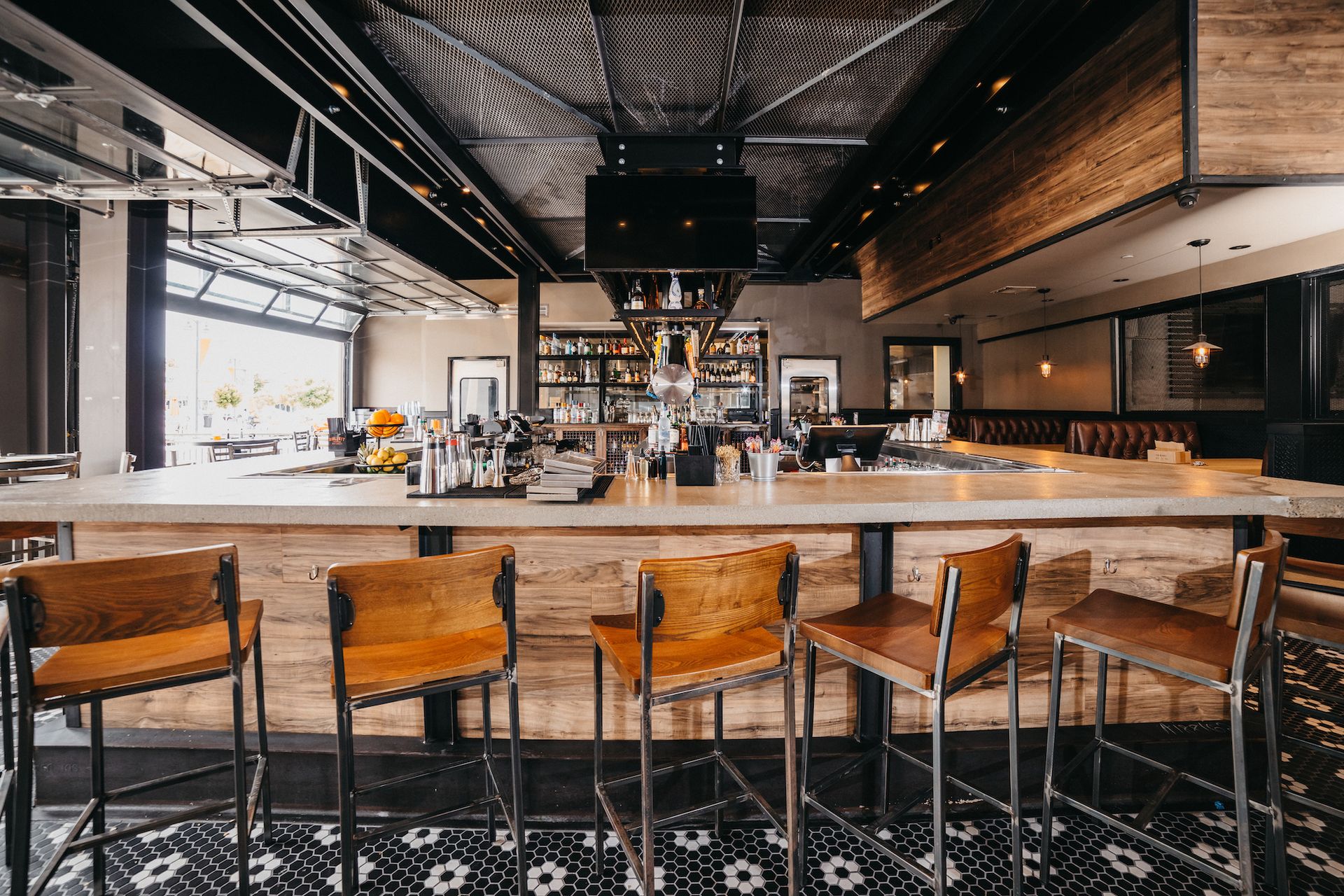 A restaurant with a long wooden bar and stools.