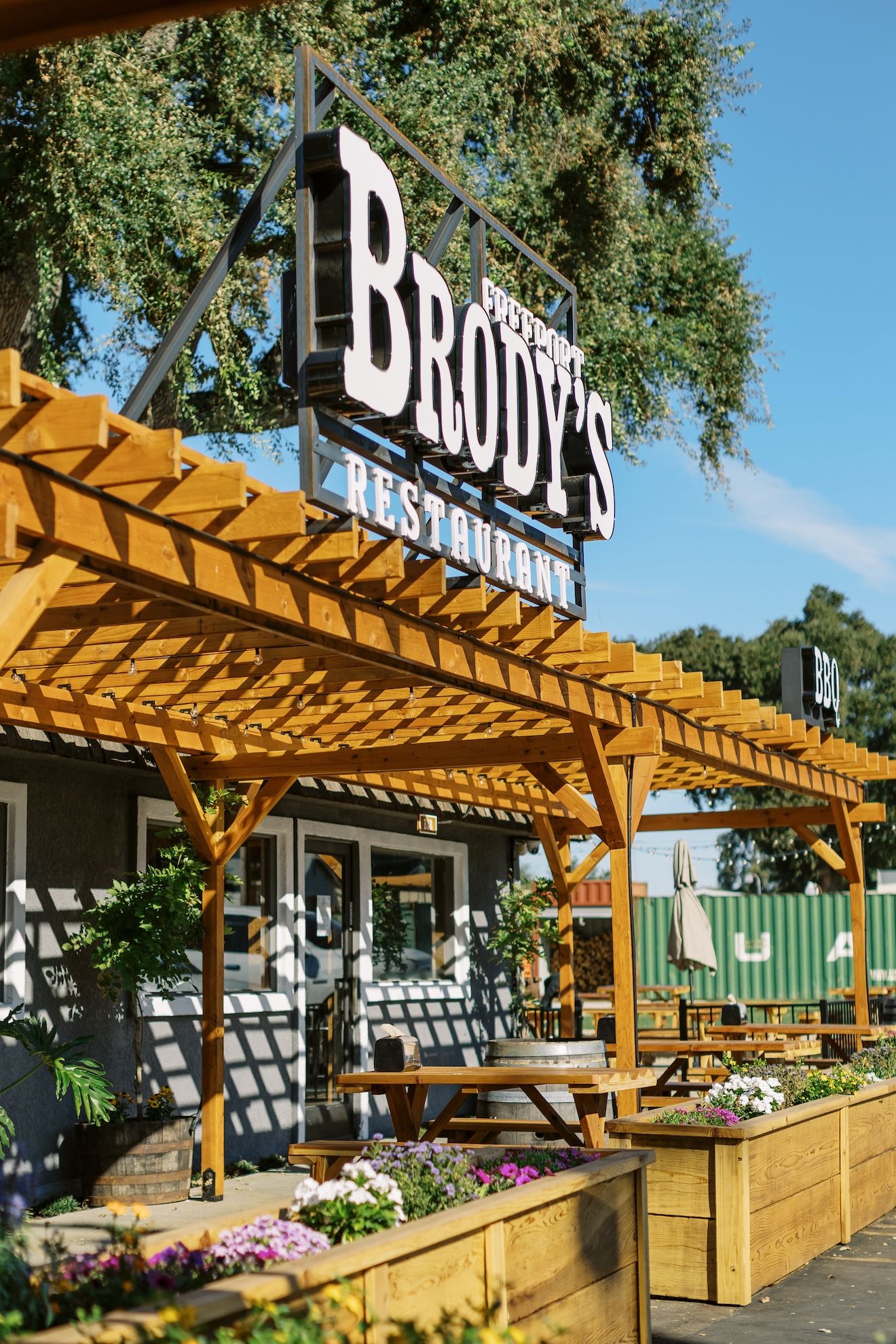 A restaurant with a wooden pergola and a sign that says `` brody 's restaurant ''.