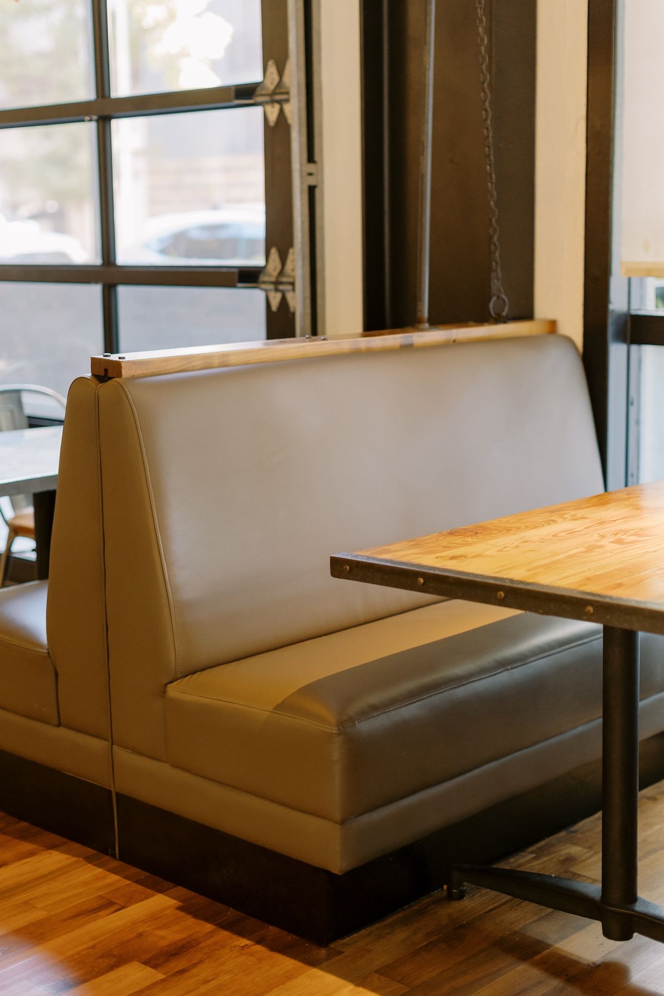 A restaurant with a booth and a table in front of a window.