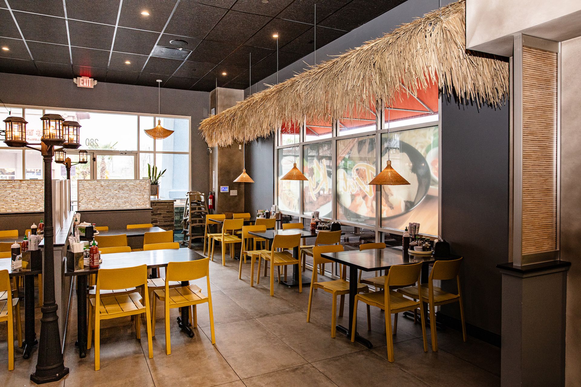 A restaurant with tables and chairs and a thatched roof