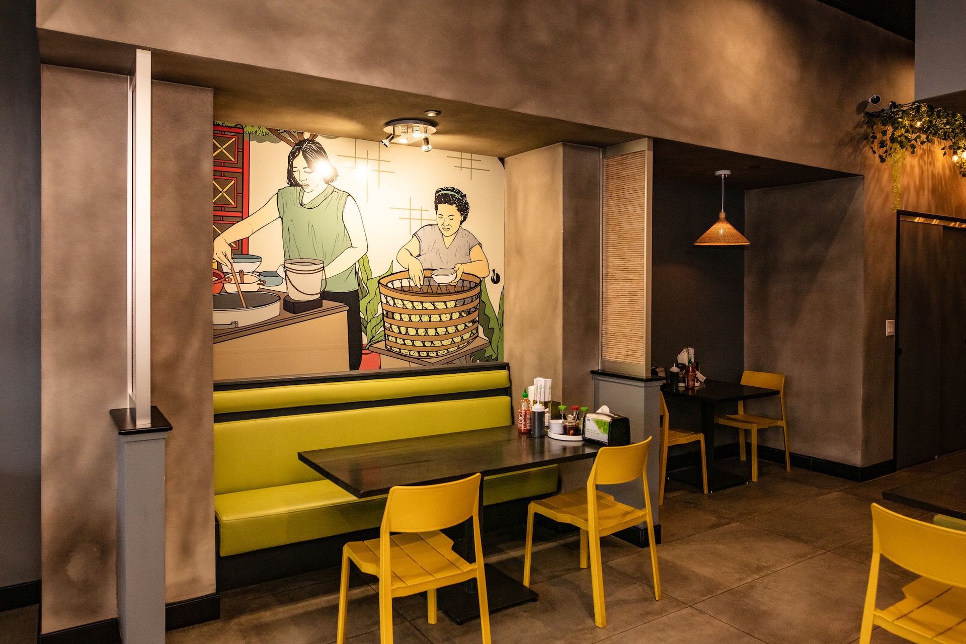 A restaurant with tables and chairs and a painting on the wall.