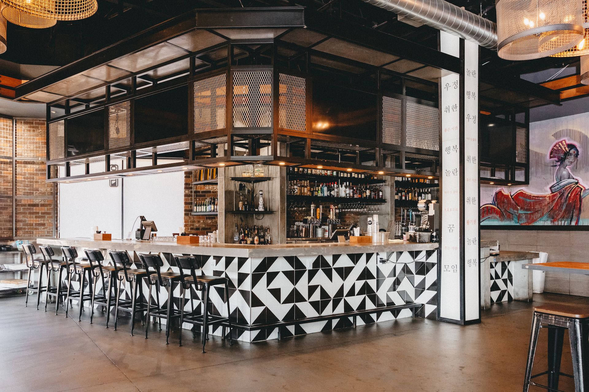 A restaurant with a long bar and stools.