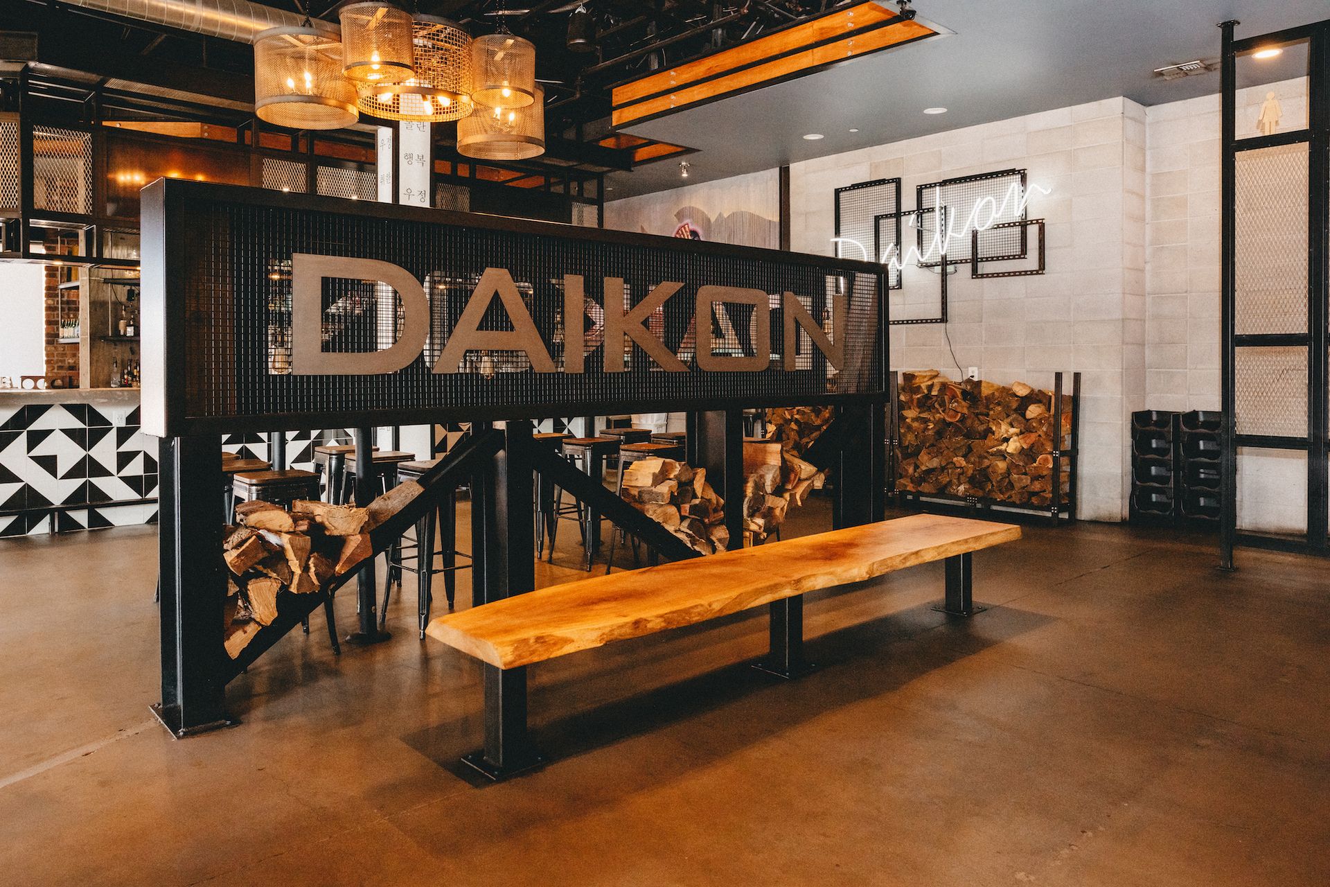A wooden bench is sitting in front of a sign that says daikon.