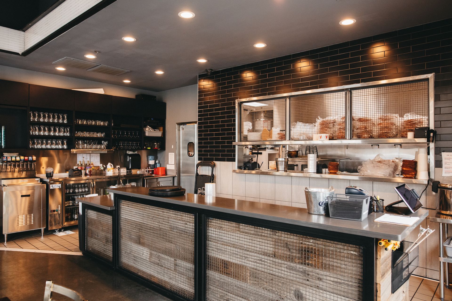 A restaurant with a long counter in the middle of the room.