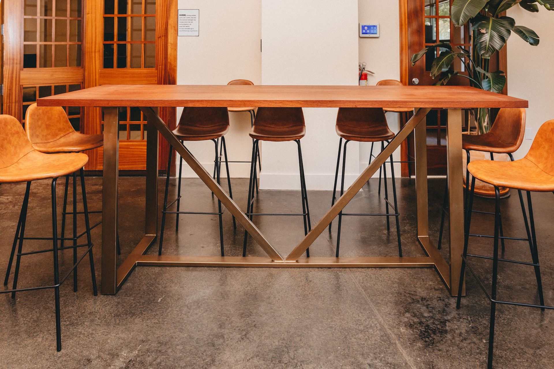 A long wooden table with stools around it in a restaurant