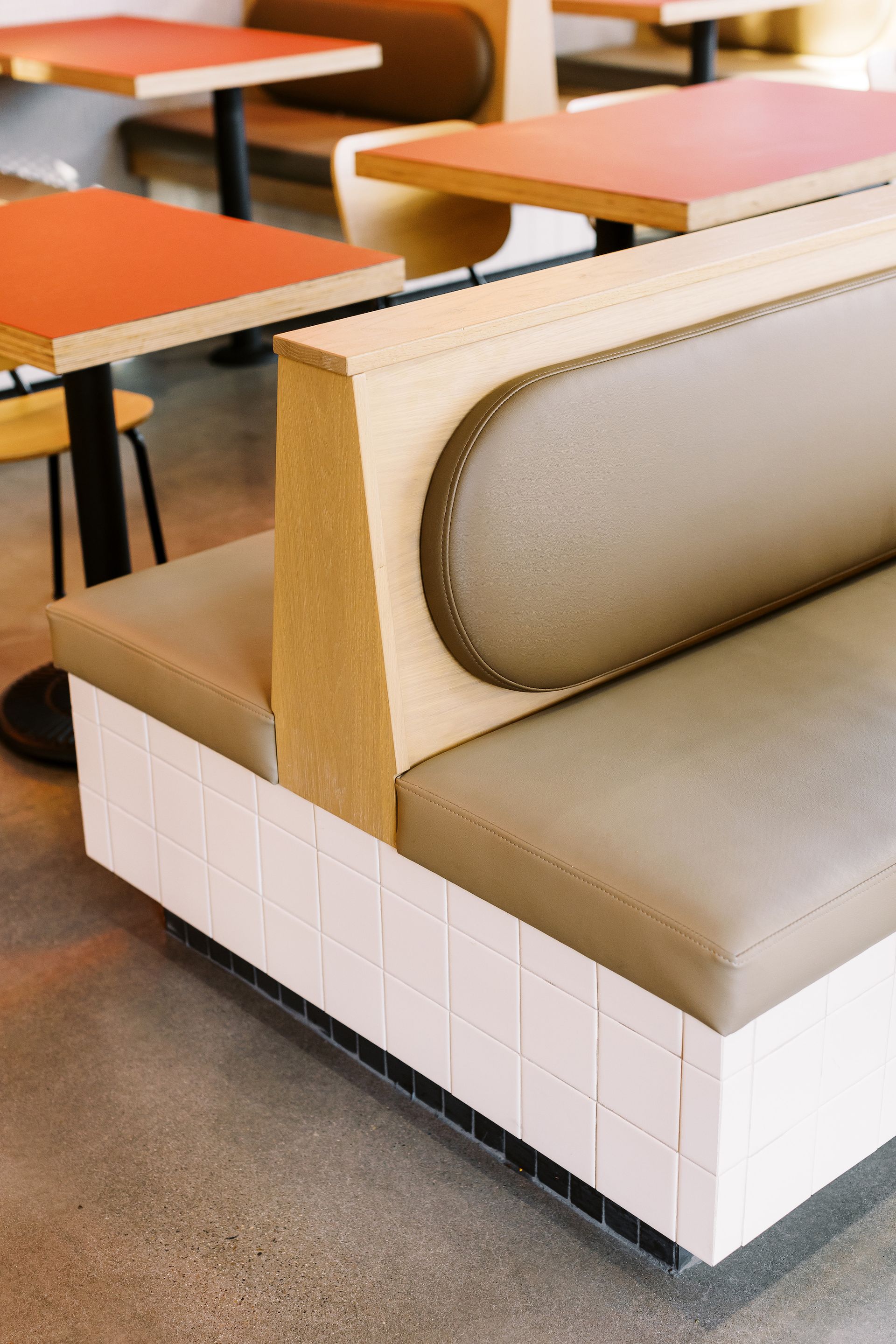 A booth in a restaurant with tables and chairs