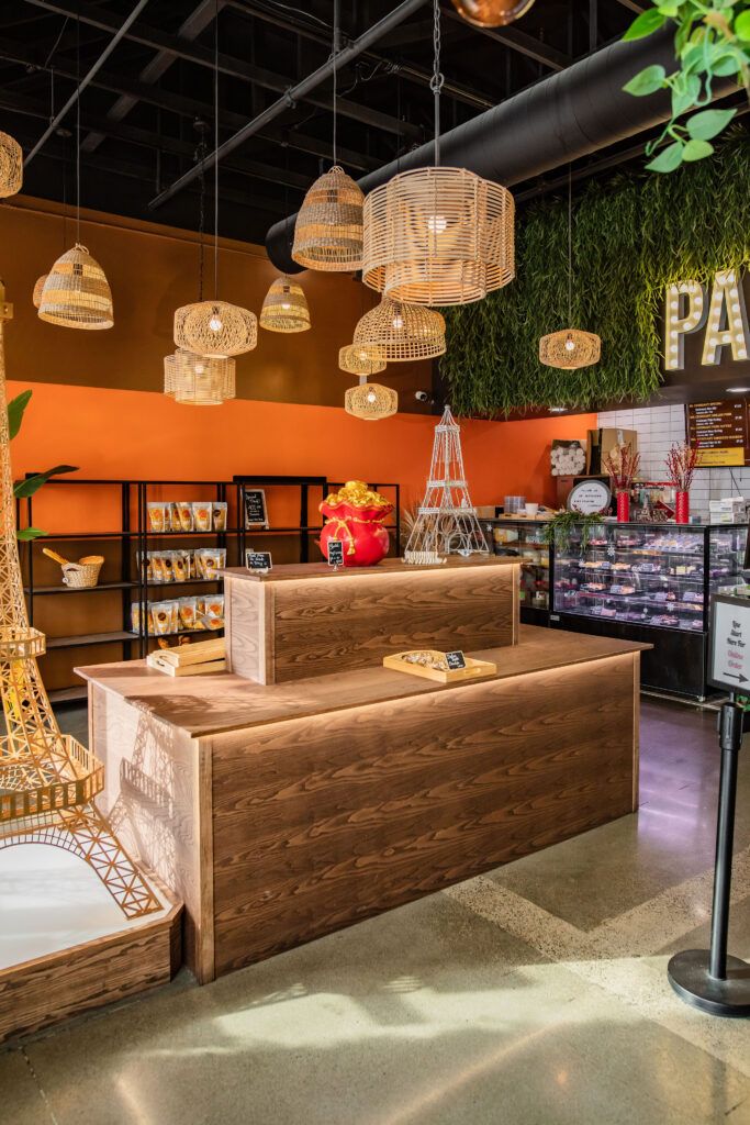 A restaurant with a wooden counter and an eiffel tower in the background.