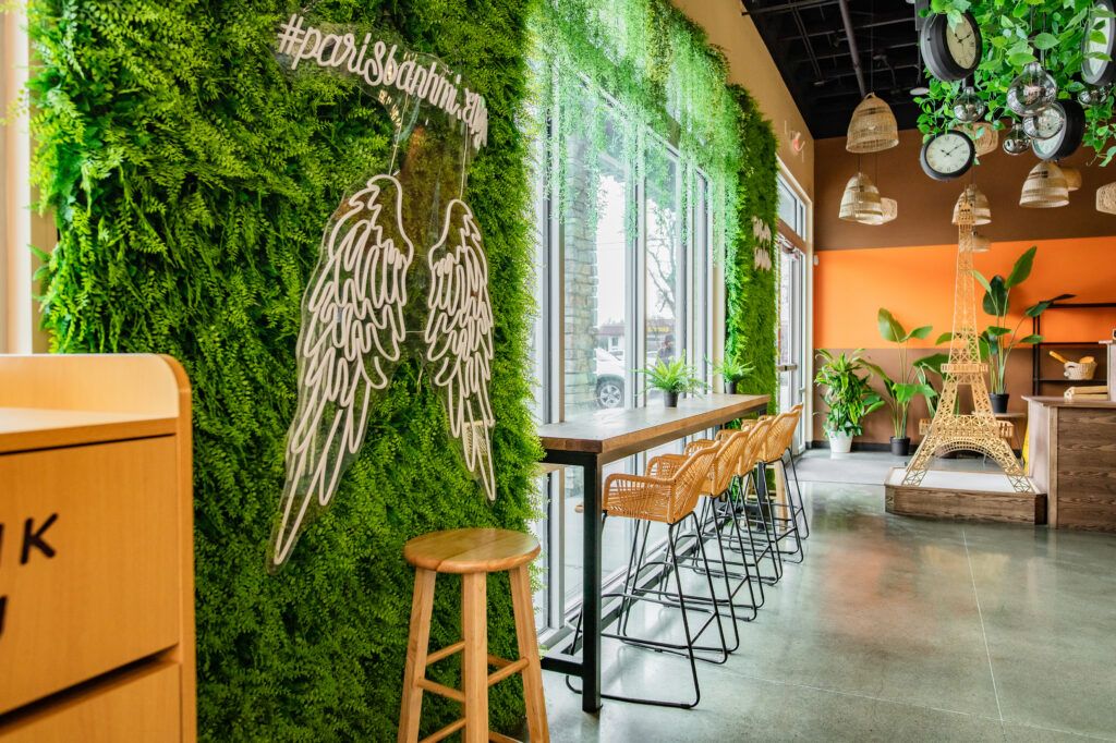 A restaurant with a green wall , tables and chairs.