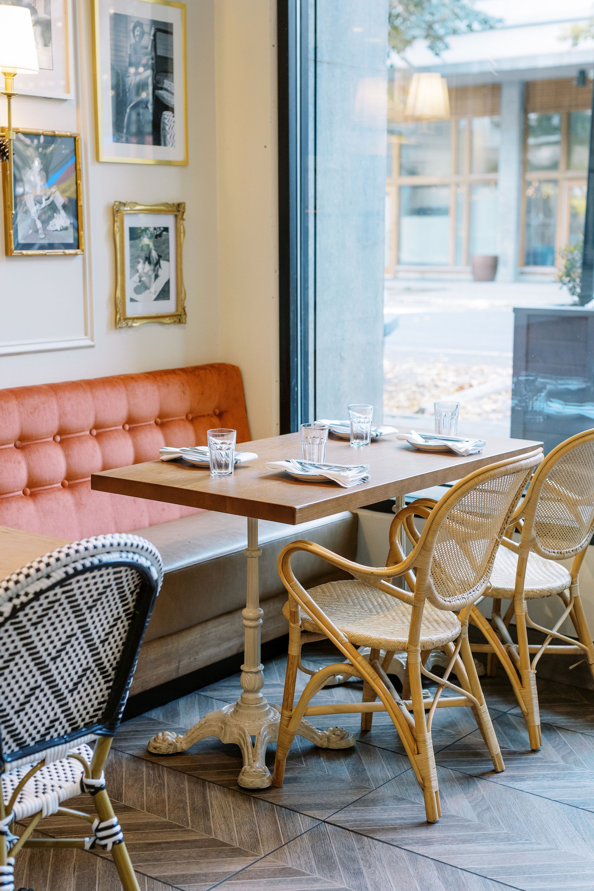 A restaurant with tables and chairs in front of a window.