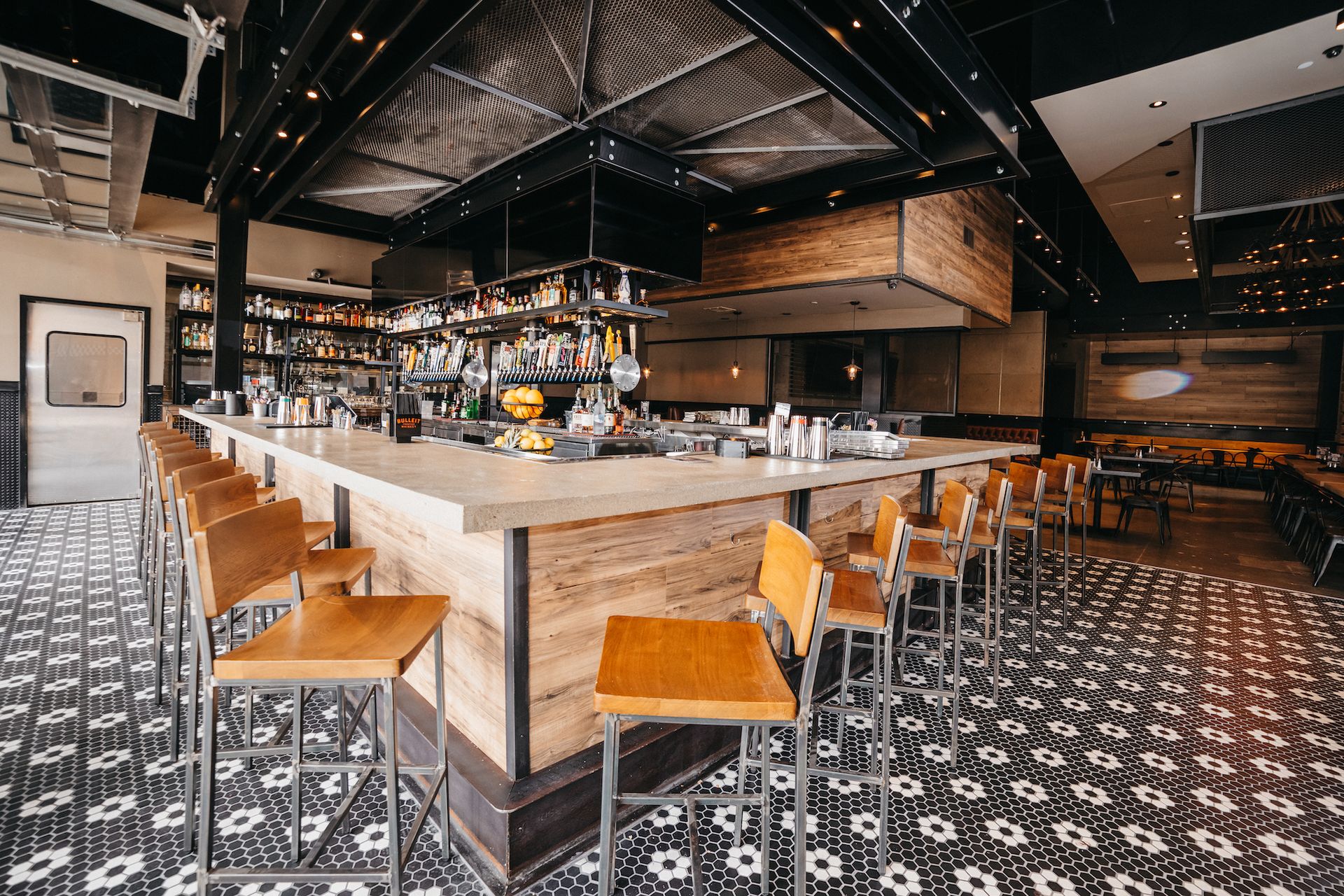 A restaurant with a long bar and lots of chairs.