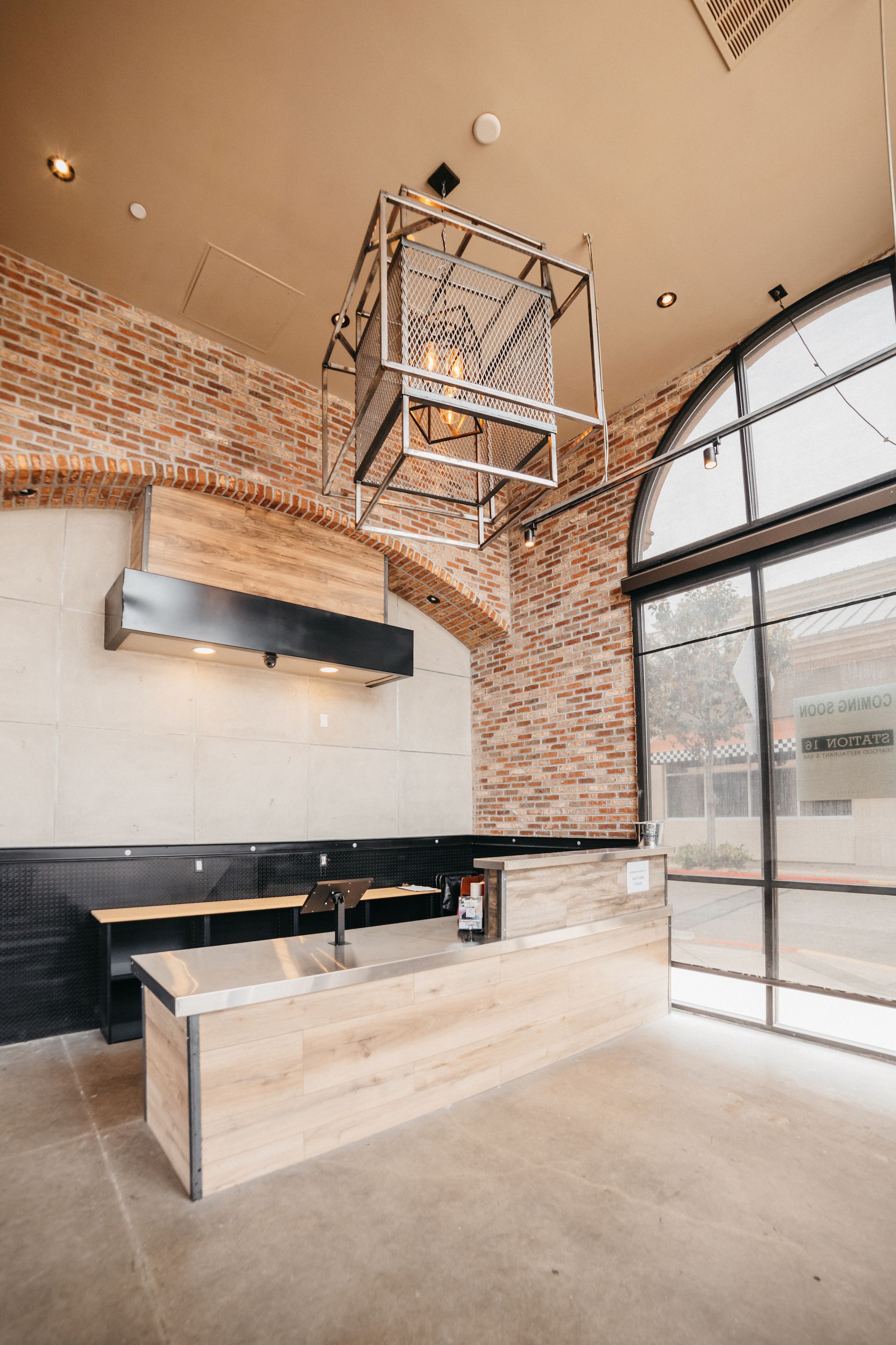 A restaurant with a brick wall and a wooden counter.