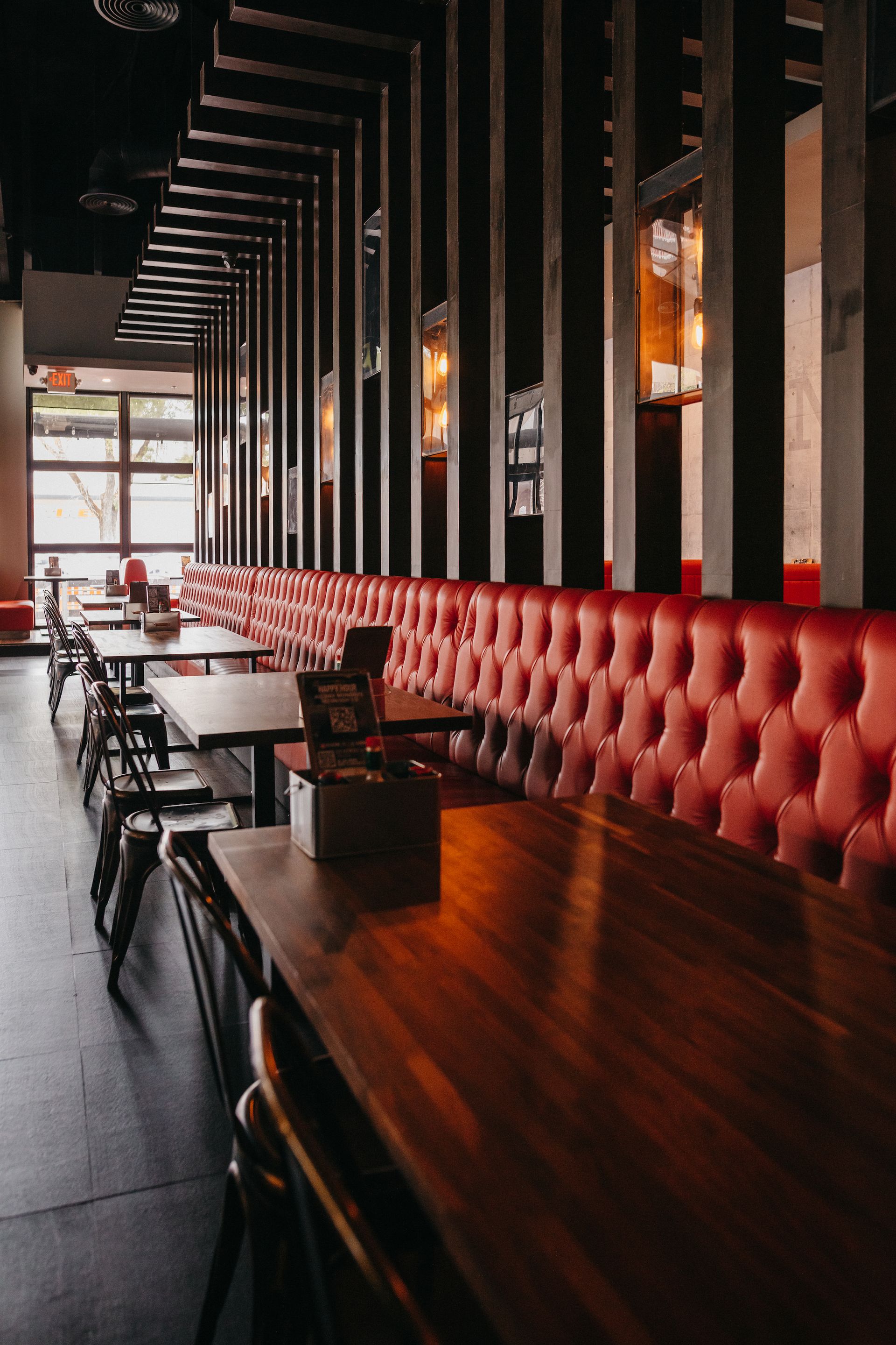 A long row of tables and benches in a restaurant.