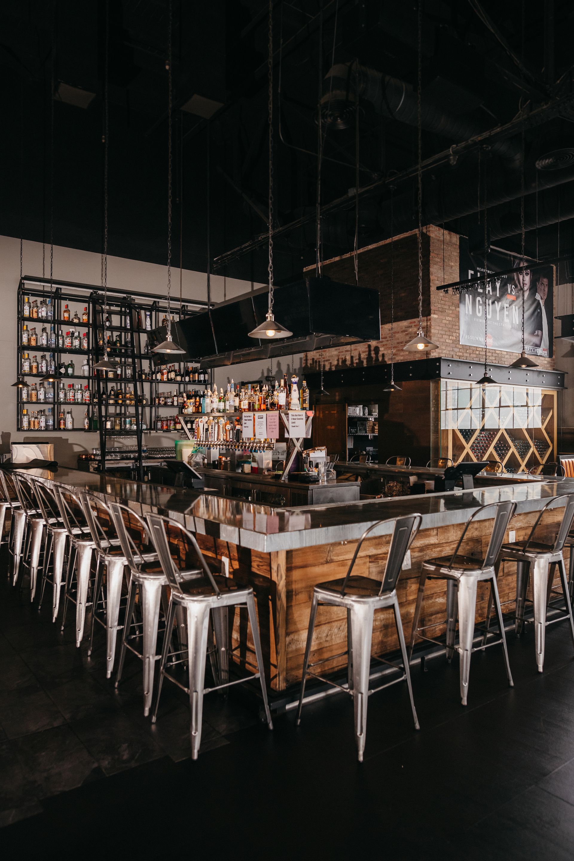 A restaurant with a long wooden bar and stools.