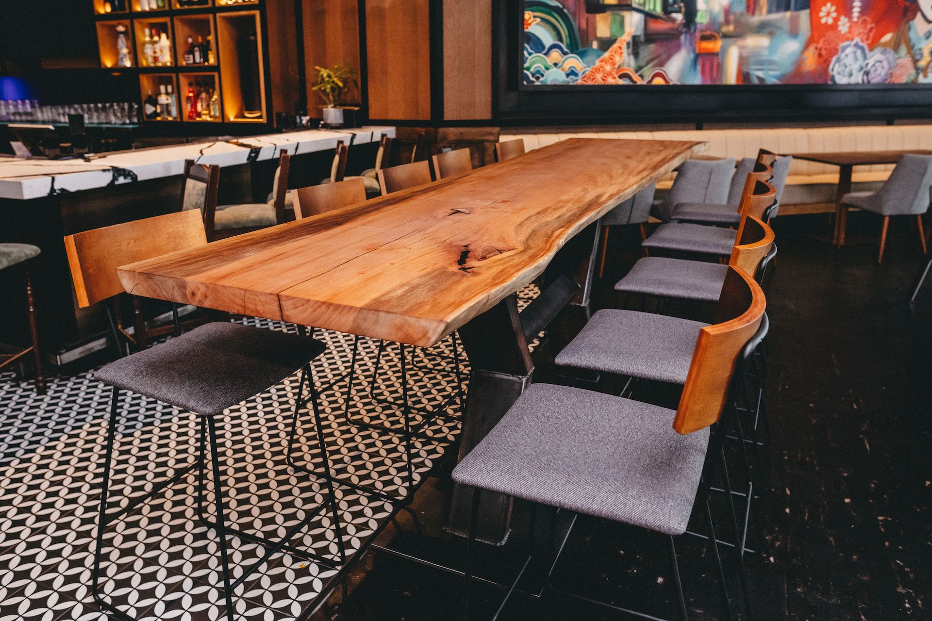 A long wooden table and chairs in a restaurant
