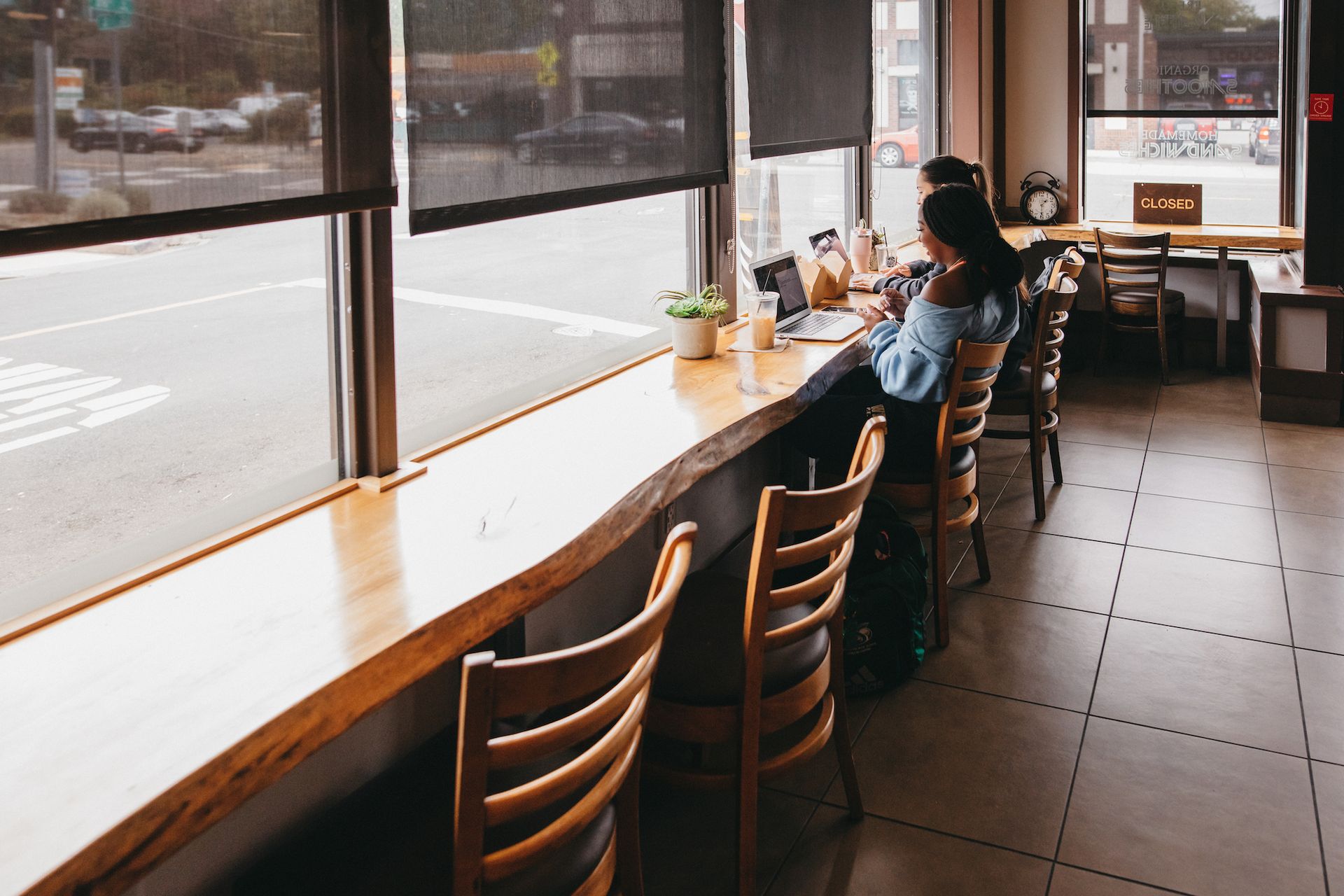 2 women sitting in a coffee shop facing the window