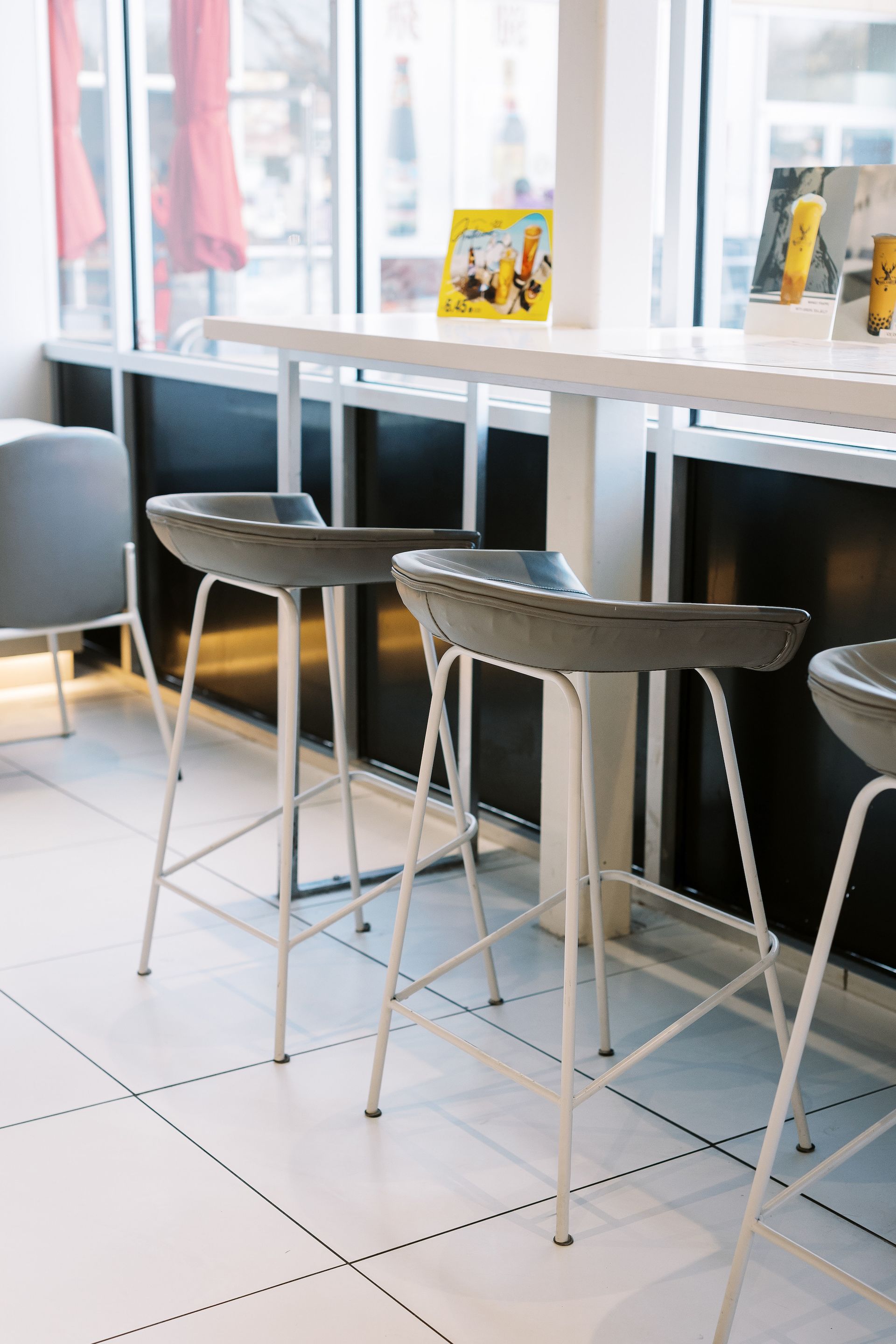 Three bar stools are sitting next to a table in a restaurant.