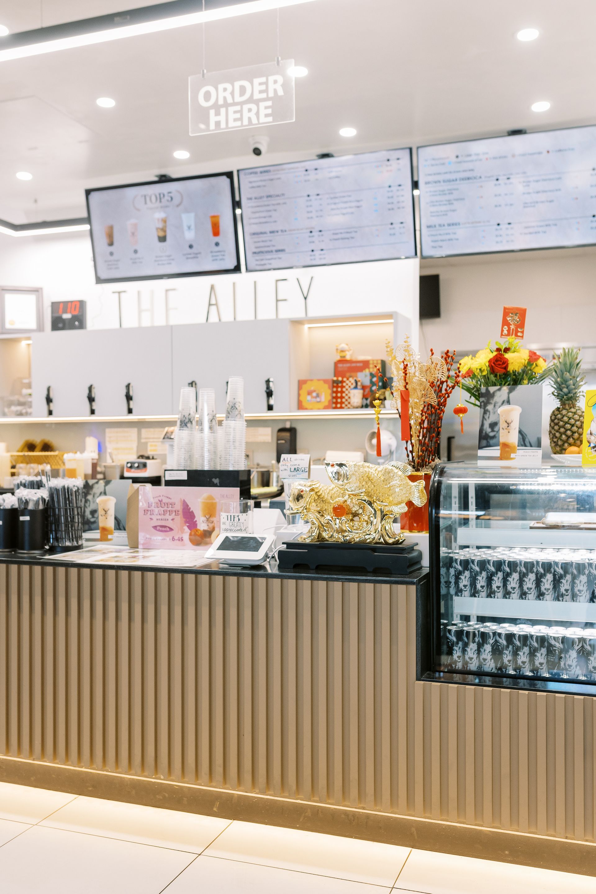 A restaurant with a counter, menus, and cash register