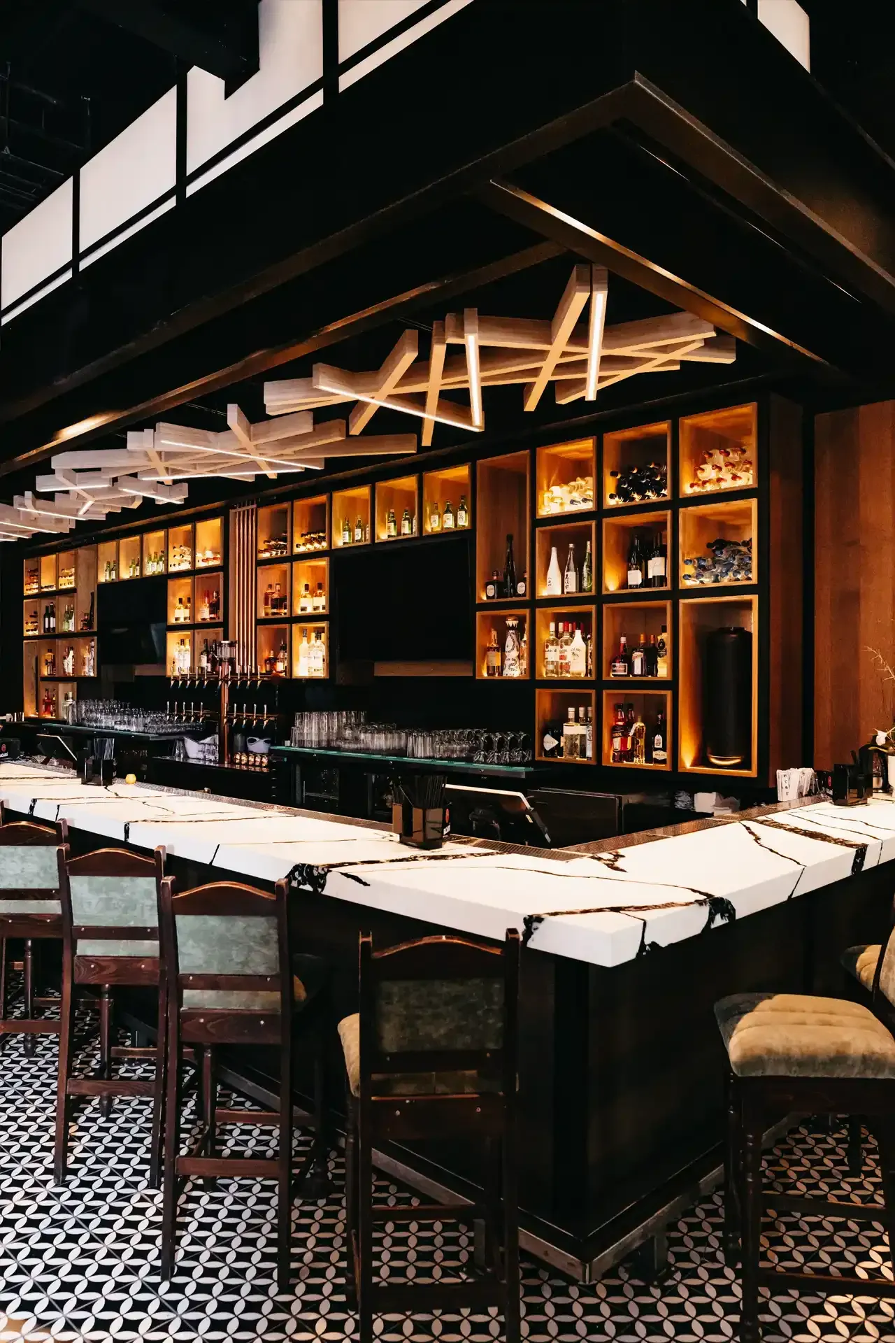 A long bar in a restaurant with a lot of bottles on it